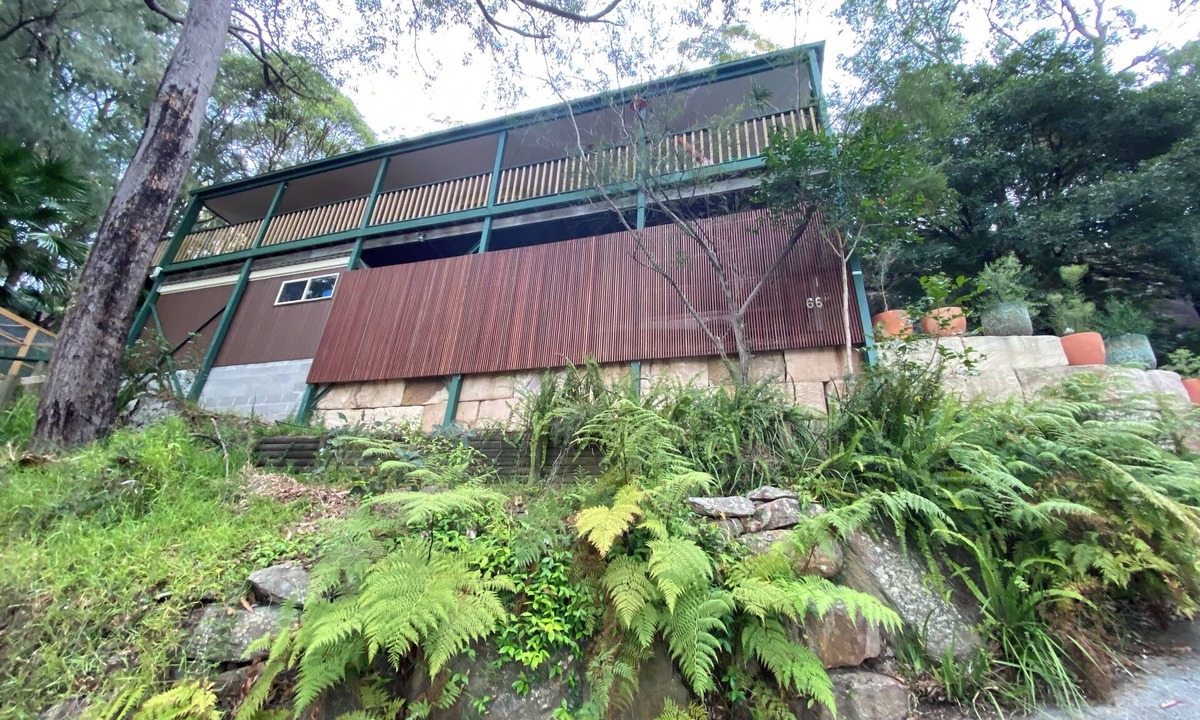 Umina Beach House | Treetops retreat - pole house set against a sandstone rock face in the tree tops