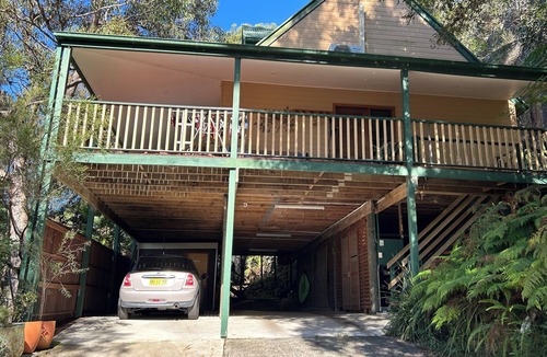 Umina Beach House | Treetops retreat - pole house set against a sandstone rock face in the tree tops